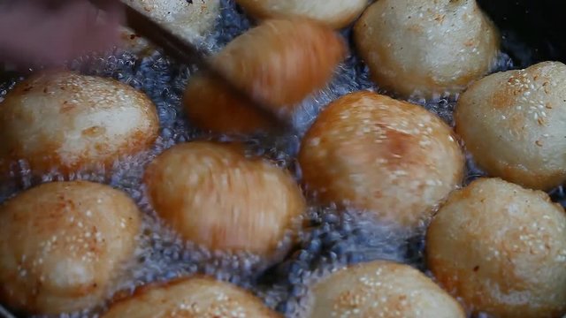 Asia. Asian street food. Fried donuts in oil