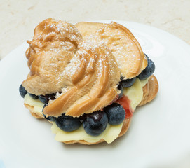 Windbeutel mit Cremefüllung und Heidelbeeren