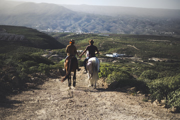 couple in love riding two beautiful horses stay together in a travel adventure for alternative...