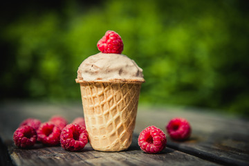ice cream in waffle Cup with raspberries berries on wooden background