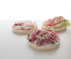Healthy snack concept Rice bread Crispy bred Radish slices Sprouts Marrow slices Cottage cheese High key Copy space