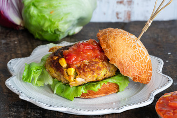 Tuna and sweetcorn burger with tomato salsa in a bun