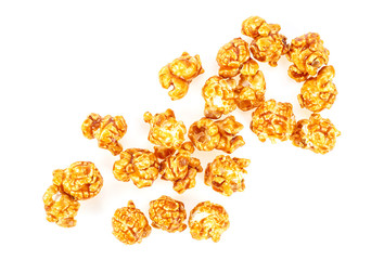 Pile of caramel corn on a white background, top view.
