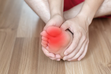 The leg hurts or itches, the man holds his leg with his hands