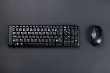 Wireless mouse with black keyboard on black surface
