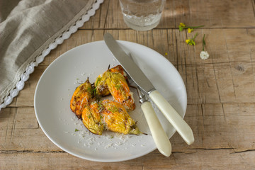 Stuffed with ricotta and cheese baked zucchini and pumpkin flowers served with a glass of mineral water. Rutik style.