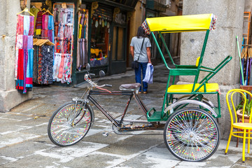 View of a delivery bike and shops in a typical street next to the Plaza Mayor in Madrid