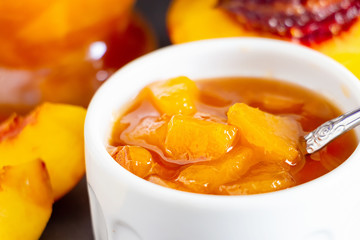 Nectarine jam confiture in ramekin and jar. Dark background. Selective focus. Close up.