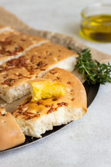 Traditional Italian focaccia with thyme on a light background.  Homemade flat bread focaccia