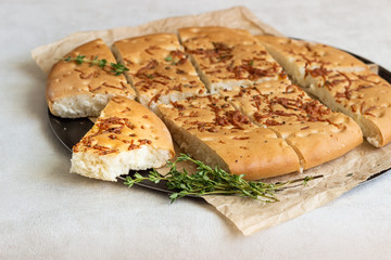 Traditional Italian focaccia with thyme on a light background.  Homemade flat bread focaccia