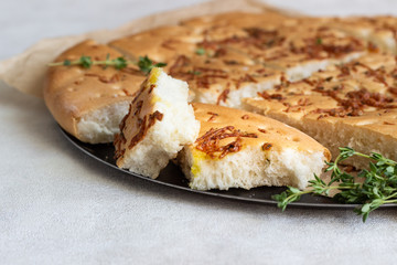 Traditional Italian focaccia with thyme on a light background.  Homemade flat bread focaccia
