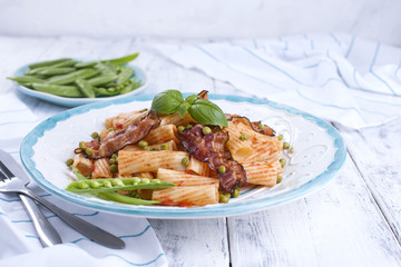 Traditional Italian food, pasta with bacon and green peas. White background. Healthy food. Copy space.