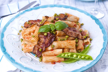 Traditional Italian food, pasta with bacon and green peas. White background. Healthy food. Copy space,