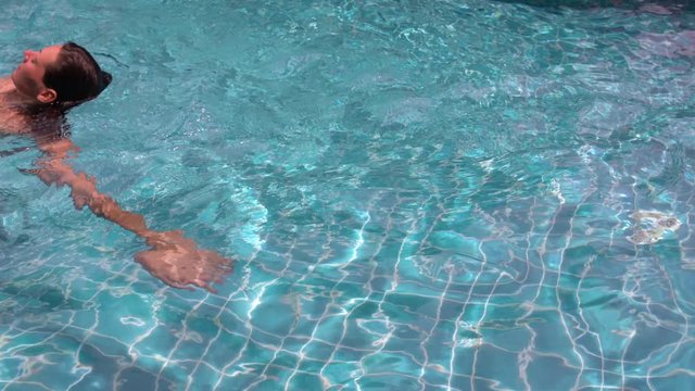 Woman swims backstroke in baseejne