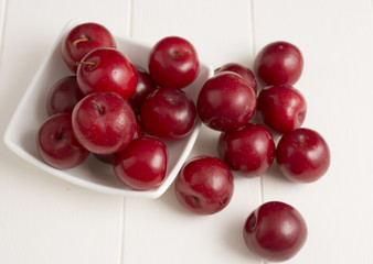 Fresh red plums, on white background.
