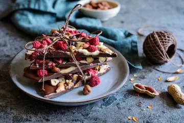 Zelfklevend Fotobehang Chocolate bark with hazelnuts, peanuts, cranberries and freeze dried raspberries © noirchocolate