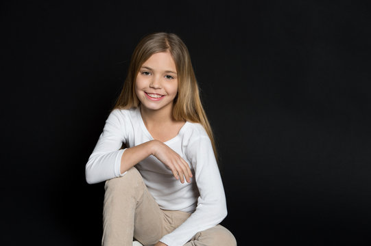 Happy Child With Fashion Hairstyle On Black Background. Little Girl Smile With Long Blond Hair. Beauty Kid Smiling With Adorable Look. Beauty Salon. Keep Calm And Get Your Hair Done