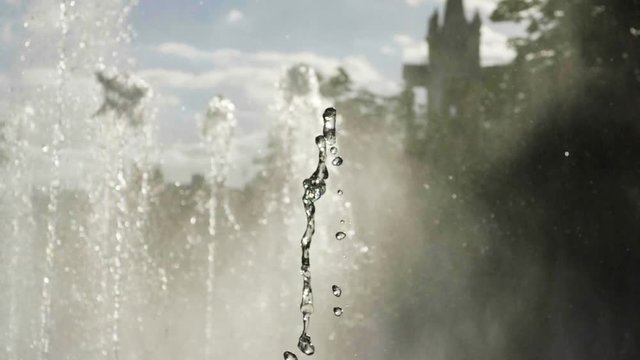 Close-up shot of water drops of fountain in the summer park. Slow motion. HD