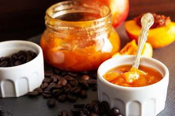 Still life with Nectarine jam in ramekin. Dark background. Selective focus. Close up.
