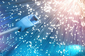 Closeup on the end of optical fiber network cable on blue background
