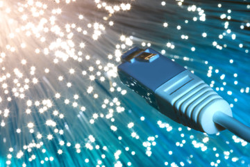 Closeup on the end of optical fiber network cable on blue background