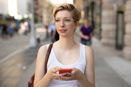 Woman in city walking texting on cell phone