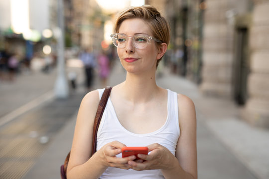 Woman in city walking texting on cell phone