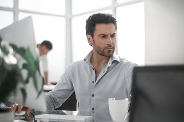 Obraz premium business man talking to a colleague sitting at his Desk