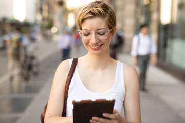 Woman in city walking using tablet computer