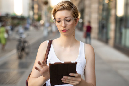 Woman in city walking using tablet computer