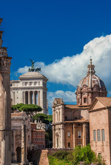 Fototapeta premium Ancient ruins, classical monuments and baroque church in the historic center of Rome (with copy space above)