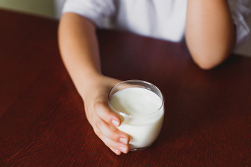 The boy is holding a glass of milk