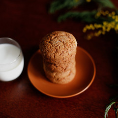 Oatmeal cookies and a glass of milk near the flowers.