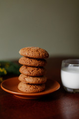 Oatmeal cookies and a glass of milk near the flowers.