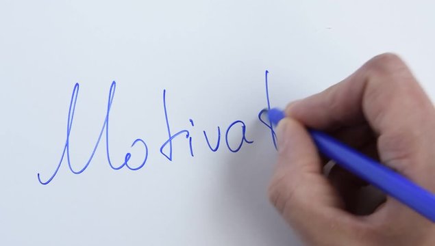 Top view of woman hand writes a phrase "Motivation" on white background