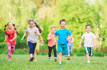 Fototapeta premium Many different kids, boys and girls running in the park on sunny summer day in casual clothes