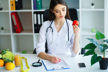 Health. The doctor signs out a diet plan. The Dietitian Holds in the Handfuls of Fresh Tomato....