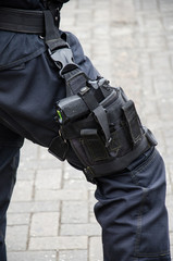 Fototapeta na wymiar Leg of a policeman in which a firearm is found, concept of security