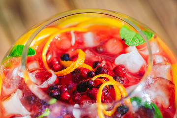 Summer cocktail. Fruit cocktail on green background. Citrus fruits, berries, strawberries, blueberries, mint, ice.