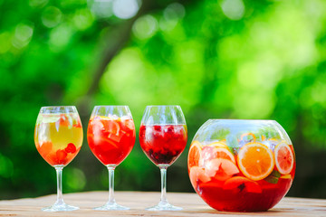 Summer cocktail. Fruit cocktail on green background. Citrus fruits, berries, strawberries, blueberries, mint, ice.