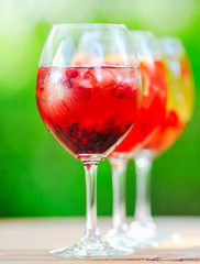 Summer cocktail. Fruit cocktail on green background. Citrus fruits, berries, strawberries, blueberries, mint, ice.