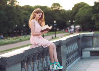 Young girl reading a book in the Park.