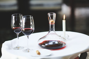 A sommelier pouring red wine into decanter