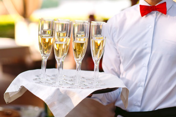 Glasses with champagne on a tray. Meeting the guests.