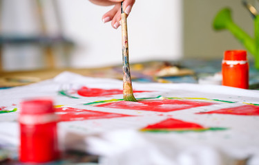 Drawing on clothes. Girl draws on a white T-shirt.