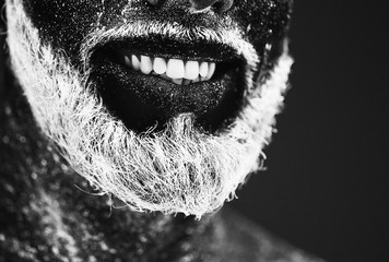 Concept. Portrait of a bearded man. The man is painted in ultraviolet powder.