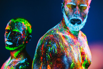 The man is decorated in a ultraviolet powder.