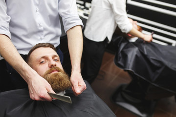 Confident mans visiting hairstylists in barber shop.