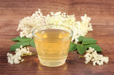 Fresh healthy juice and elderberry flowers on rustic board