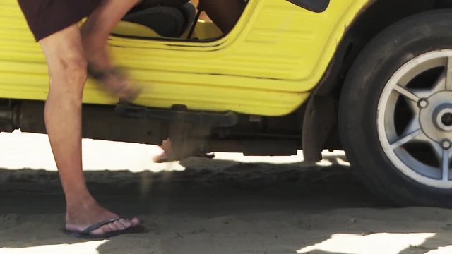 Undressing On The Beach. Clothes Falling Inside Of A Yellow Car.
